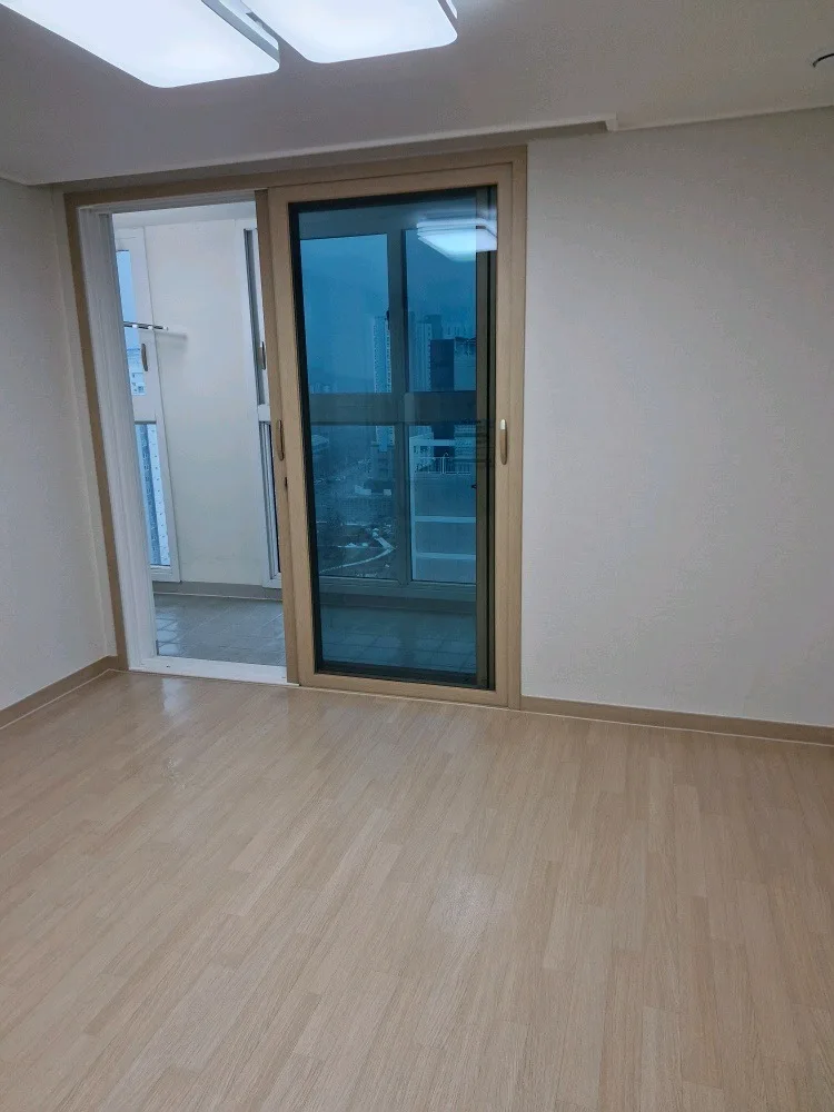 청소 후 비어 있고 정돈된 거실과 베란다 창